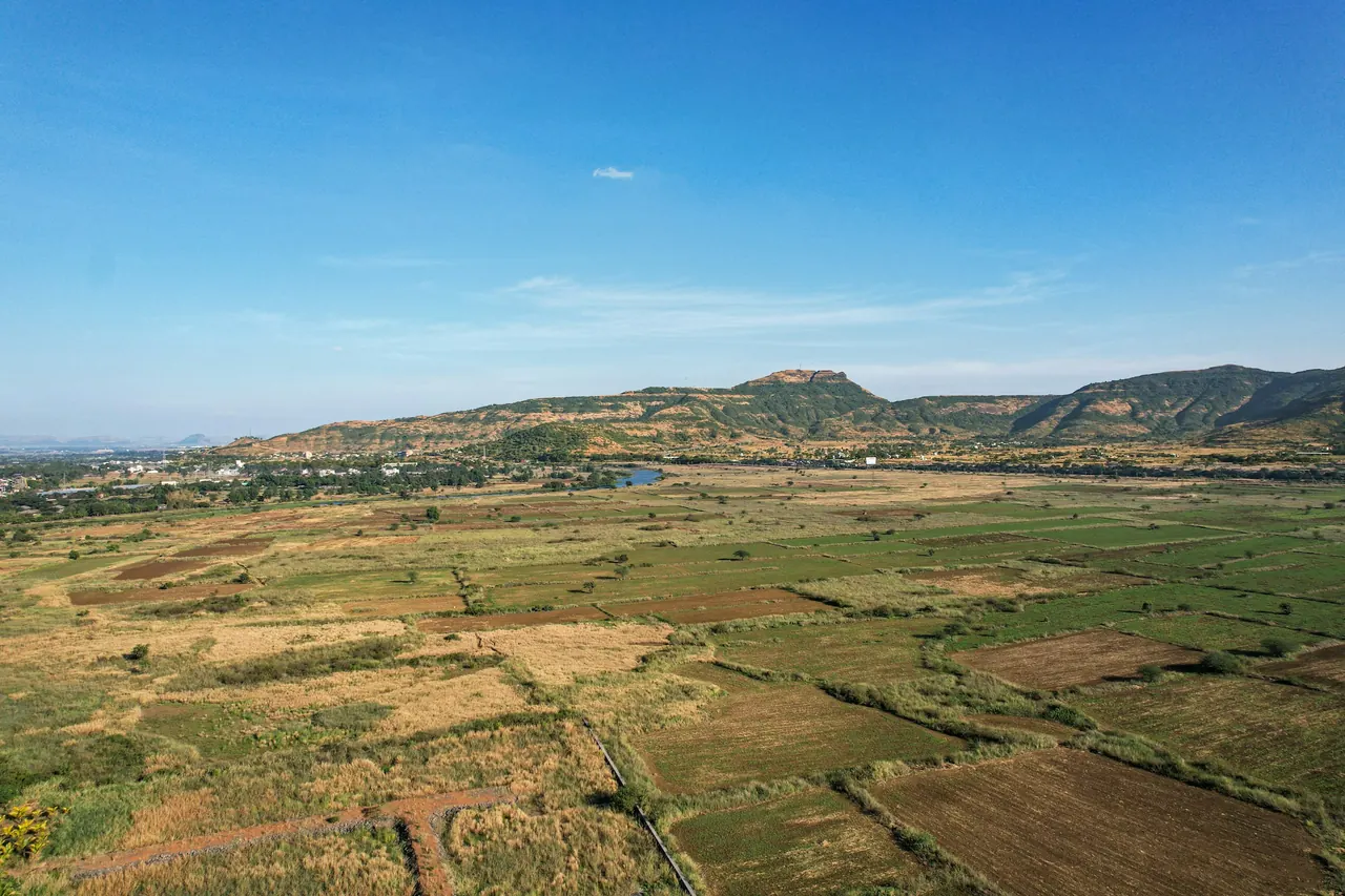 Patchwork farmland in a wide valley beneath low hills