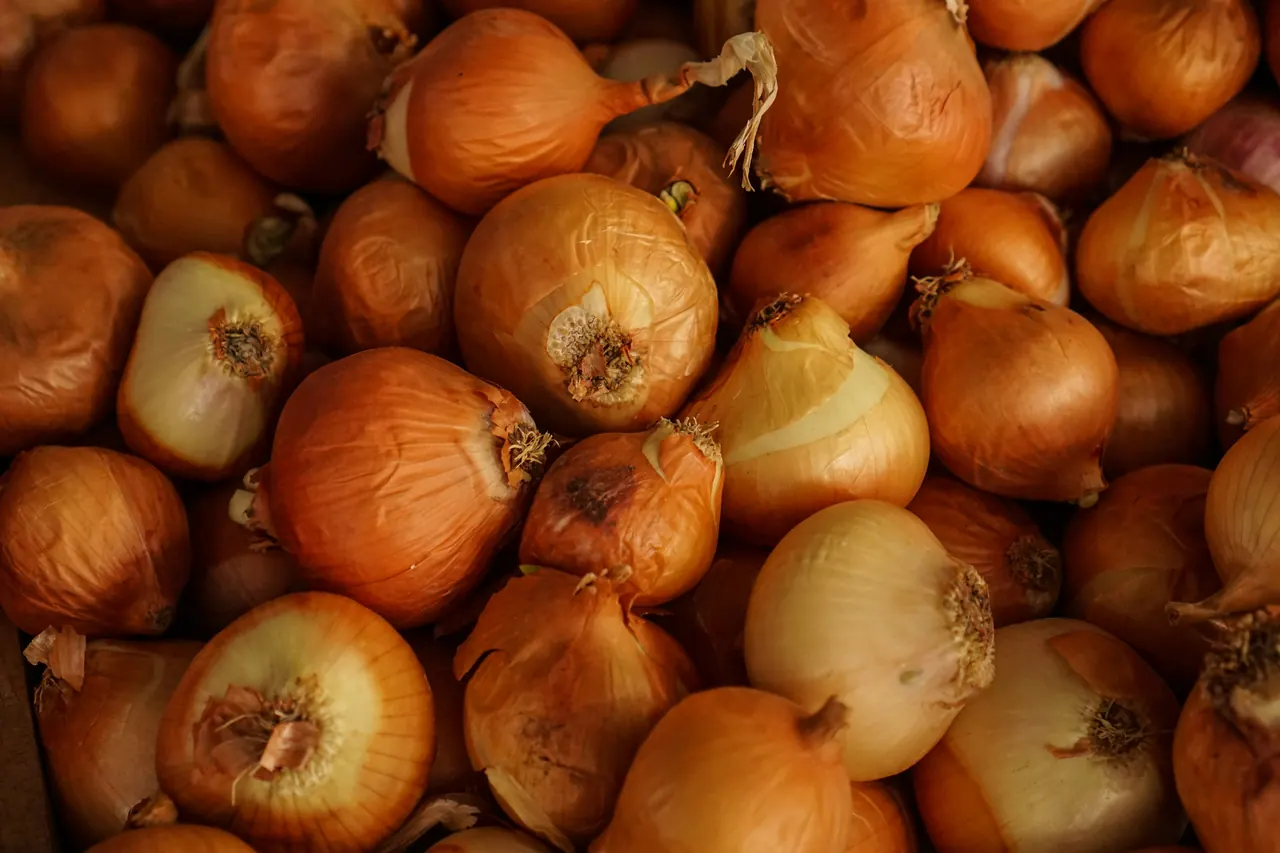 Stacked onion bulbs on display at a produce market